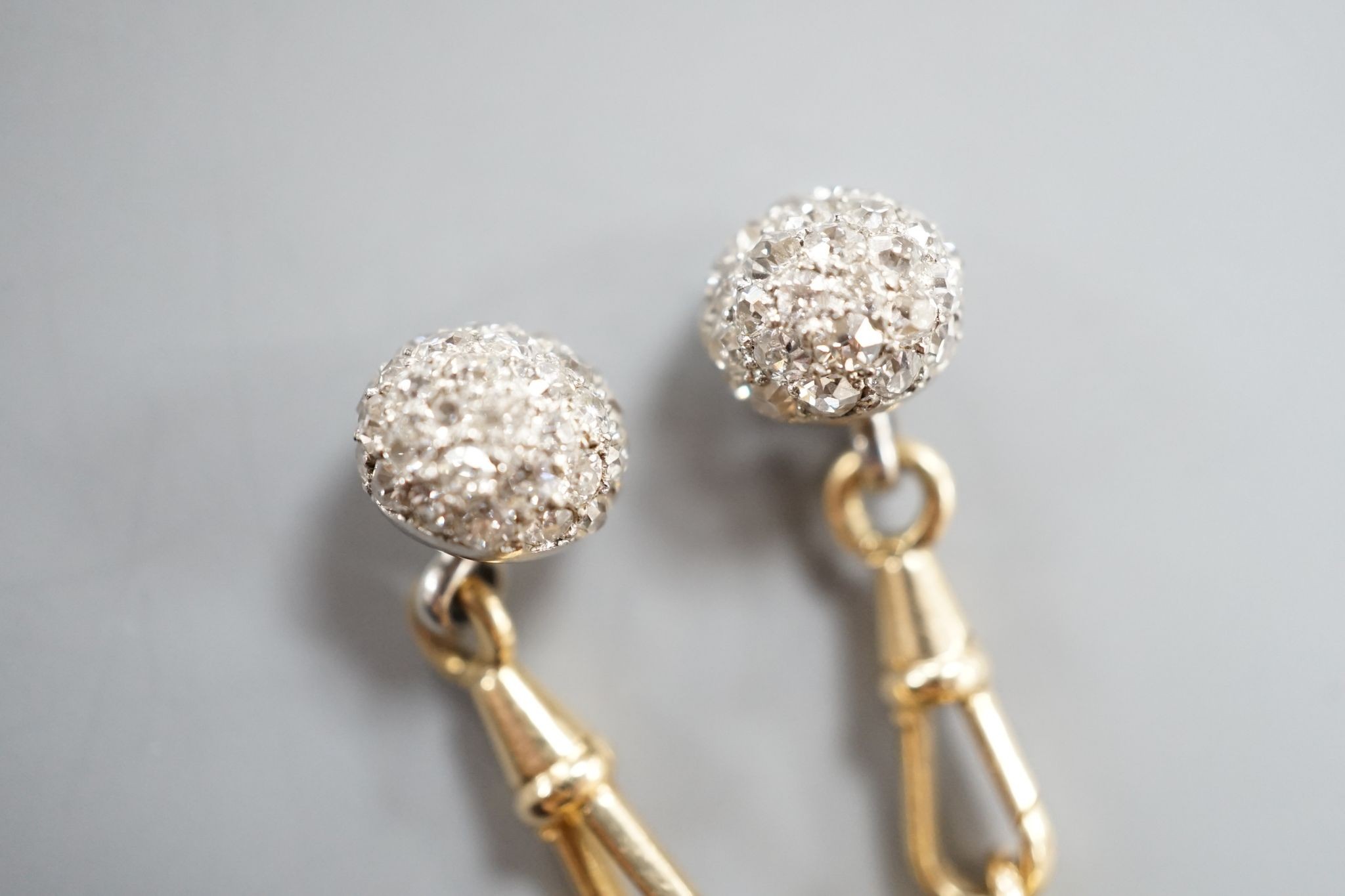A pair of yellow metal and pave set ruby and diamond cufflinks (adapted), gross weight 10 grams.